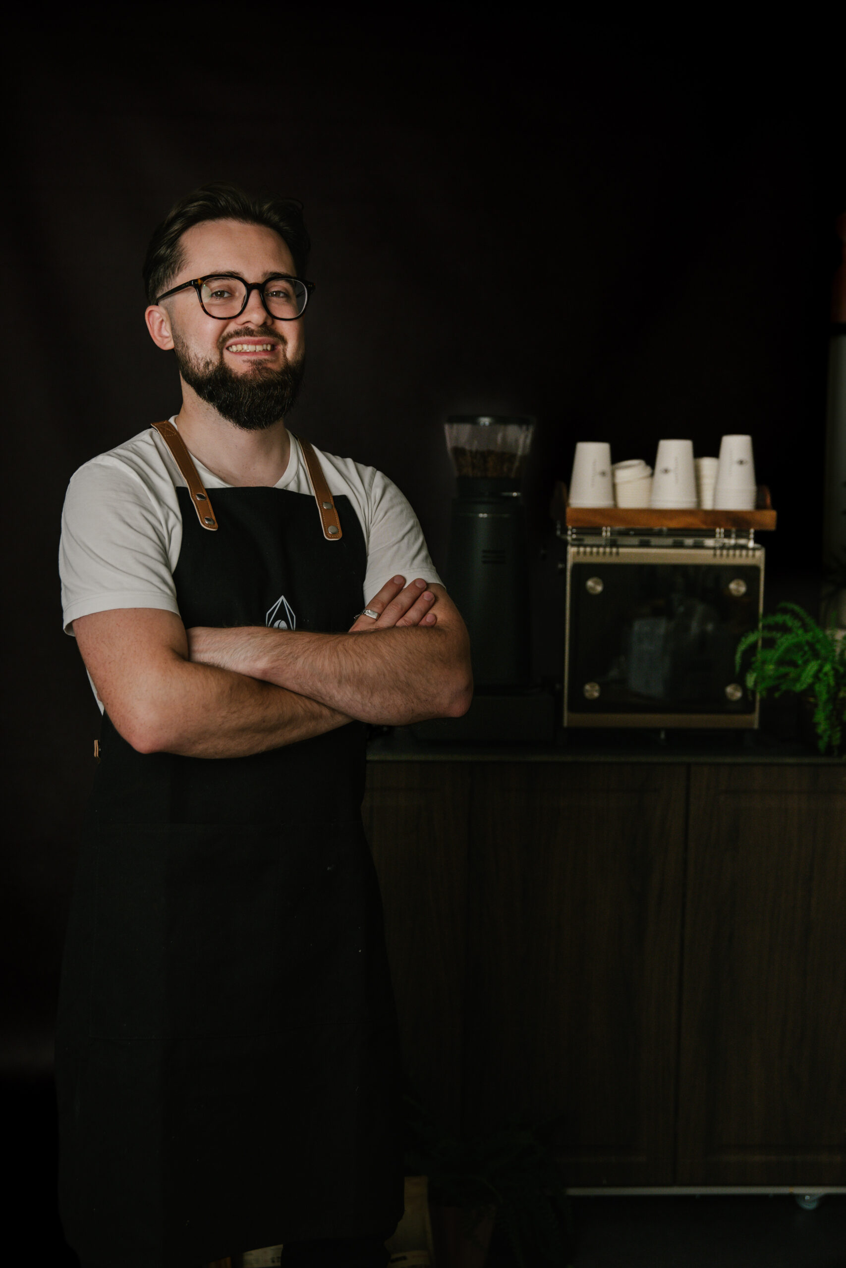Barista Topola Cafe stoi na tle wózka kawowego z ekspresem dalla corte mina i młynkiem compak i3 pro